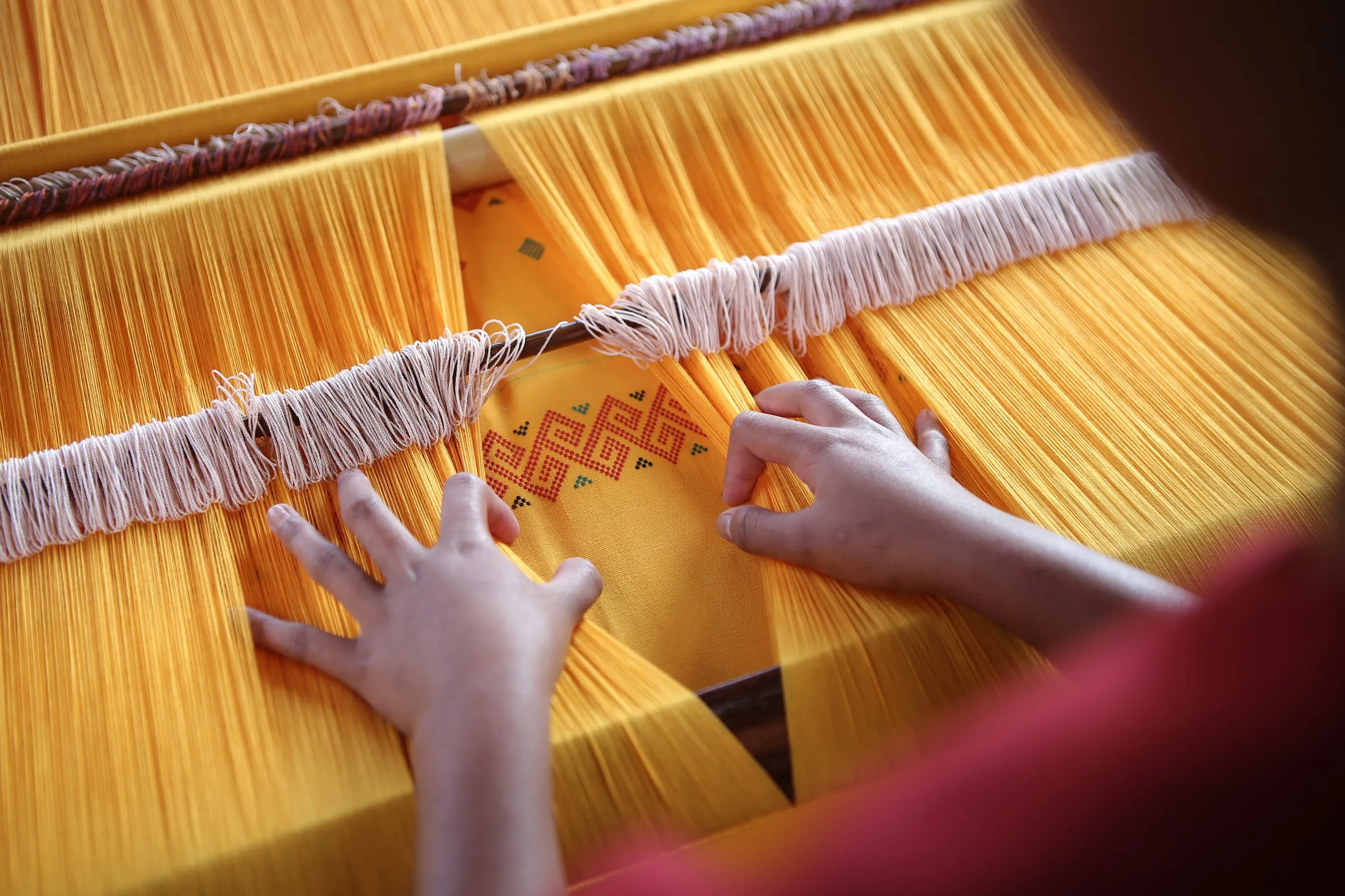 Seorang penenun mengerjakan kain ikat di alat tenun tradisional, Toraja